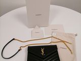 the saint laurent wallet bag is sitting on a table next to a box