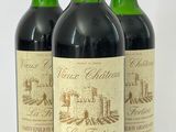 trois bouteilles de vin rouge posées sur une table blanche