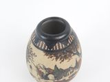a small vase with a painting on it on a white surface
