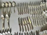 a lot of silver spoons and forks on the table