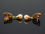 pair of pearl and gold earrings on a black surface