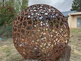 une grosse boule métallique posée sur une souche d'arbre