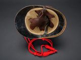 a brown and black hat with a red cord attached to it