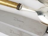 three silver and gold spoons and a knife on a table