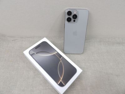 Un iPhone 11 Pro de la marque Apple est posé à côté d'une boîte sur un canapé
