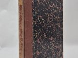 an old book sitting on top of a white surface