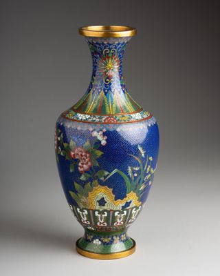 un vase bleu bordé d'or sur un fond blanc
