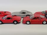 several toy cars are lined up in a row on a white surface