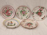 quatre assiettes à motifs différents posées sur une surface blanche
