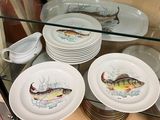 a lot of plates with fish on them in a glass case