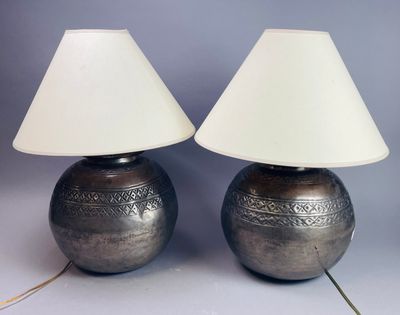 une paire de lampes en forme de vases en argent, surmontées d'abat-jour blancs