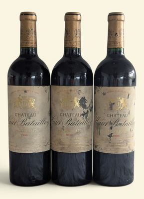 three bottles of red wine sitting next to each other on a white surface