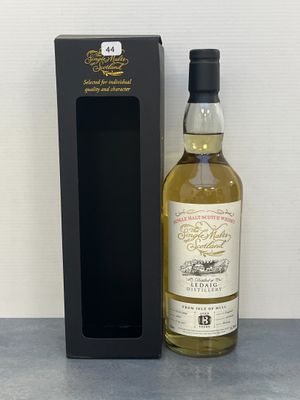 une bouteille de whisky posée à côté d'une boîte noire sur une table