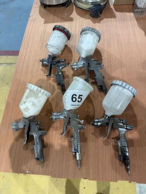 many spray guns sitting on a table in a room