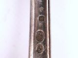 a silver spoon with a handle on a white surface