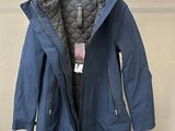 une veste suspendue à un cintre devant un mur, avec une étiquette de prix