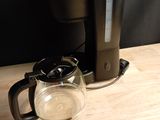 a coffee maker and a glass cup on a table