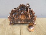a metal spoon and spoon holder on a wooden table