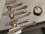 beaucoup de cuillères en argent et de cuillères à soupe sur une table