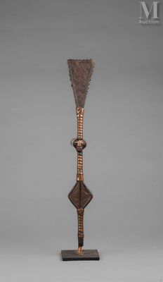 a bronze sculpture of a spear on a wooden base