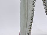 someone is wearing a pair of grey boots with studs on them