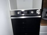 a black and white oven in the corner of a kitchen