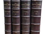 six vieux livres sont empilés sur une surface blanche