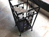 a black metal table with a glass top on a tiled floor