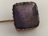 an image of a close up of a ring with a purple stone on it