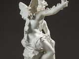 a statue of a woman sitting on a rock
