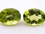 pair of two green and yellow gems on a white surface