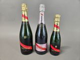 three bottles of champagne sitting next to each other on a table