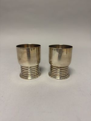 pair of silver plated cups on a white background