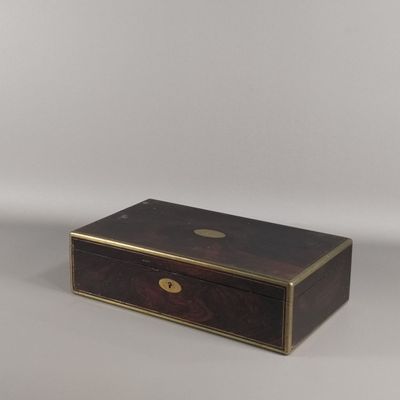 une petite boîte en bois avec une plaque en laiton sur le couvercle