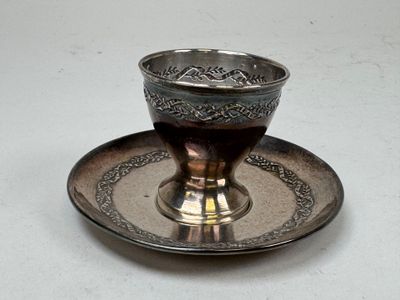 une tasse et une soucoupe en argent posées sur un plateau en argent