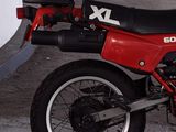 a red and black motorcycle parked in a parking lot