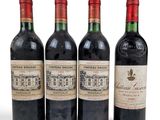 three bottles of red wine sit next to each other on a white surface