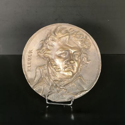 a close up of a metal plate with a face on it