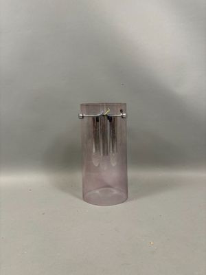 un vase en verre orné d'une horloge, posé sur une table