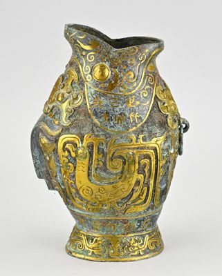 un vase doré et bleu orné d'un oiseau