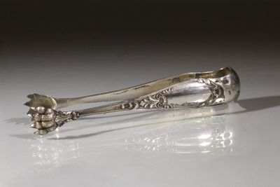 une cuillère en argent ornée d'une fleur, posée sur une table