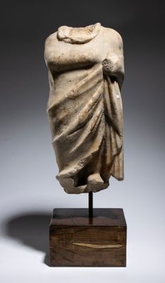 une statue antique représentant une femme vêtue d'une robe drapée, posée sur un socle en bois