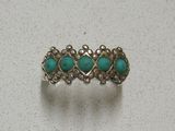 un gros plan d'une bague en argent sertie de pierres de turquoise