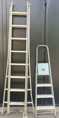 two ladders next to each other on the sidewalk