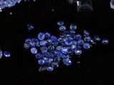 some very pretty blue crystals on a black surface with a black background