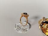 a gold ring with a black stone on it next to a gold ring with a black stone on it
