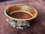 un gros plan sur un bracelet en or orné de fleurs