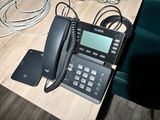 a telephone that is sitting on a table next to a cell phone