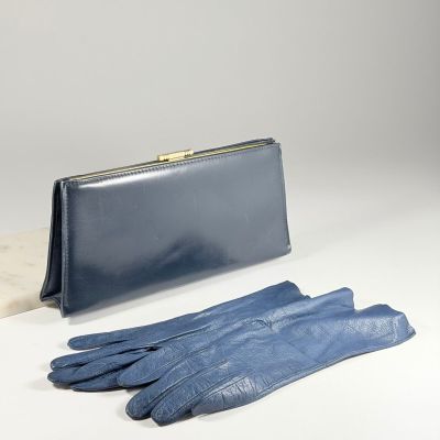 des gants en cuir bleus et un sac à main bleu posés sur une surface blanche