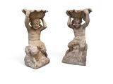 une paire de statues représentant un garçon et une fille portant un panier sur la tête